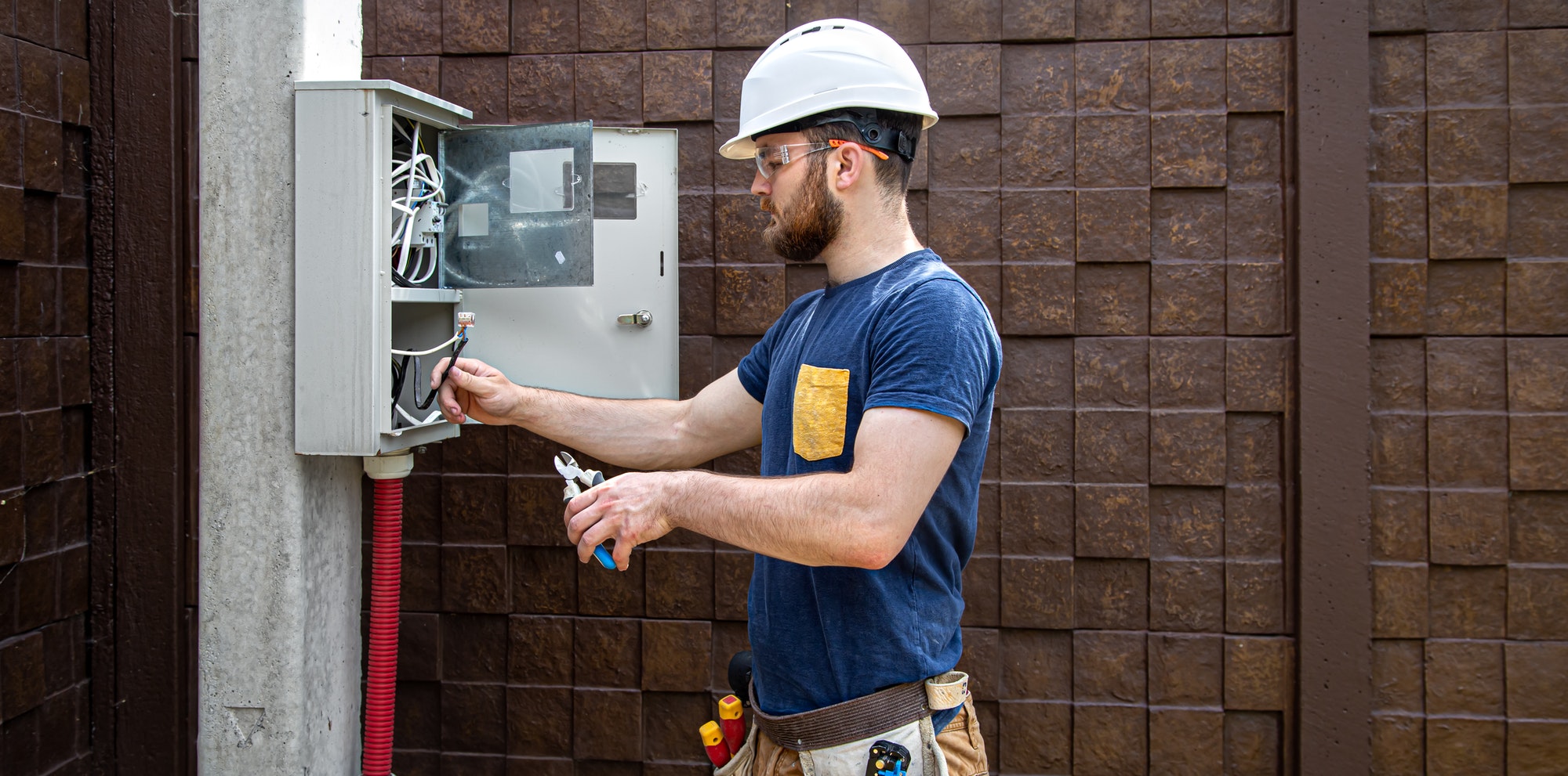 Electrician Builder at work, examines the cable connection in the electrical line in the fuselage.